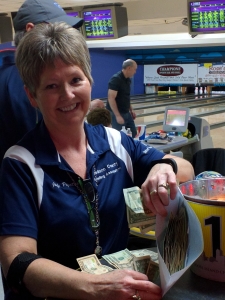 Judy Poynter of the Madison County Bowling Association happily counts funds raised at a recent Lemetta Dause Memorial Tournament. This year's event is Feb. 4.